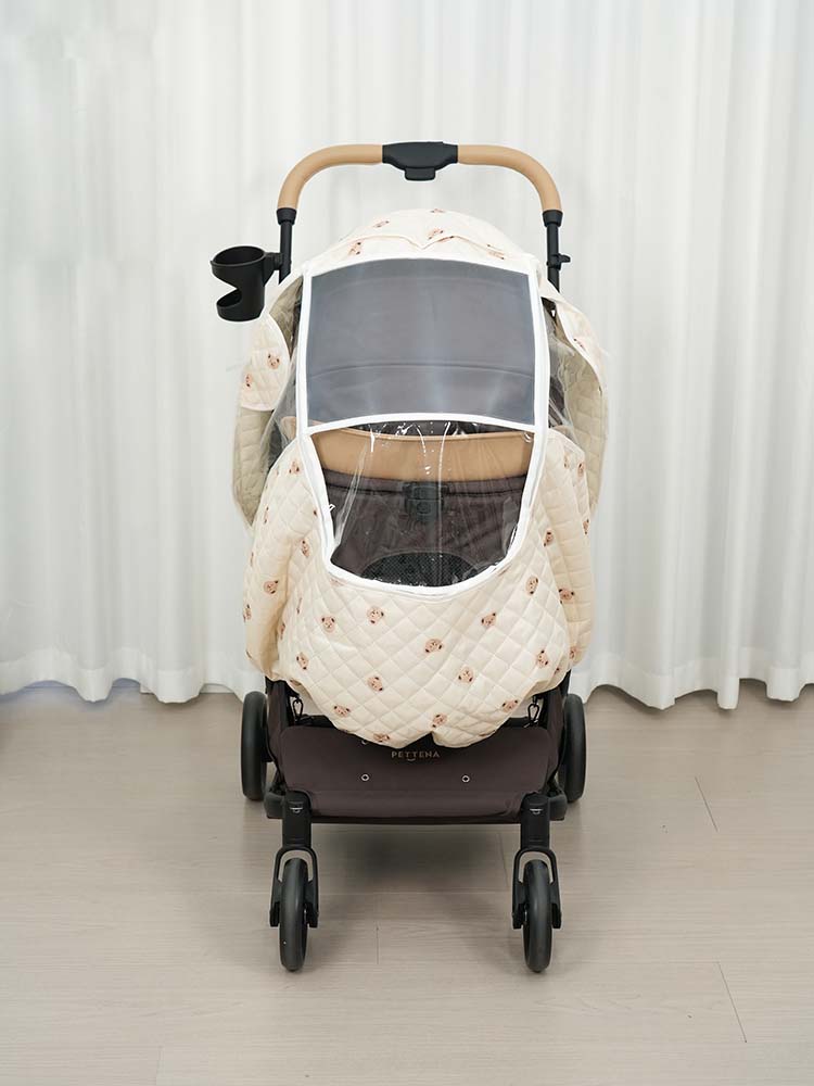 正面から見たペットカート用レインカバー。大きな透明窓とベージュのテディベア柄キルティングが特徴的で、愛犬の視認性と防寒性を兼ね備えたMILOU・ORION専用品。