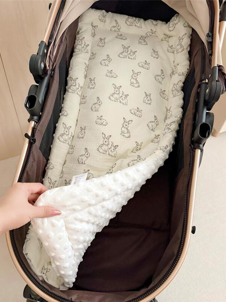 PETTENA、TERRA専用。カート内部に敷いたウサギ柄マットの拡大図。手でめくって裏面の白いドットボア素材を見せており、表裏で異なる肌触りが確認できるリバーシブル仕様です。