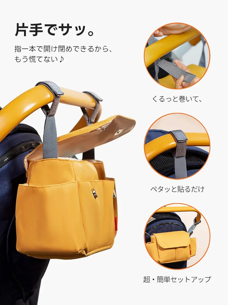 マスタード色のバッグをペットカートに装着する手順。マジックテープをハンドルに巻いて貼るだけの簡単セットアップ。片手でサッと開閉できるマグネット式の蓋など、忙しい散歩中でも操作が楽な工夫が視覚的に分かります。
