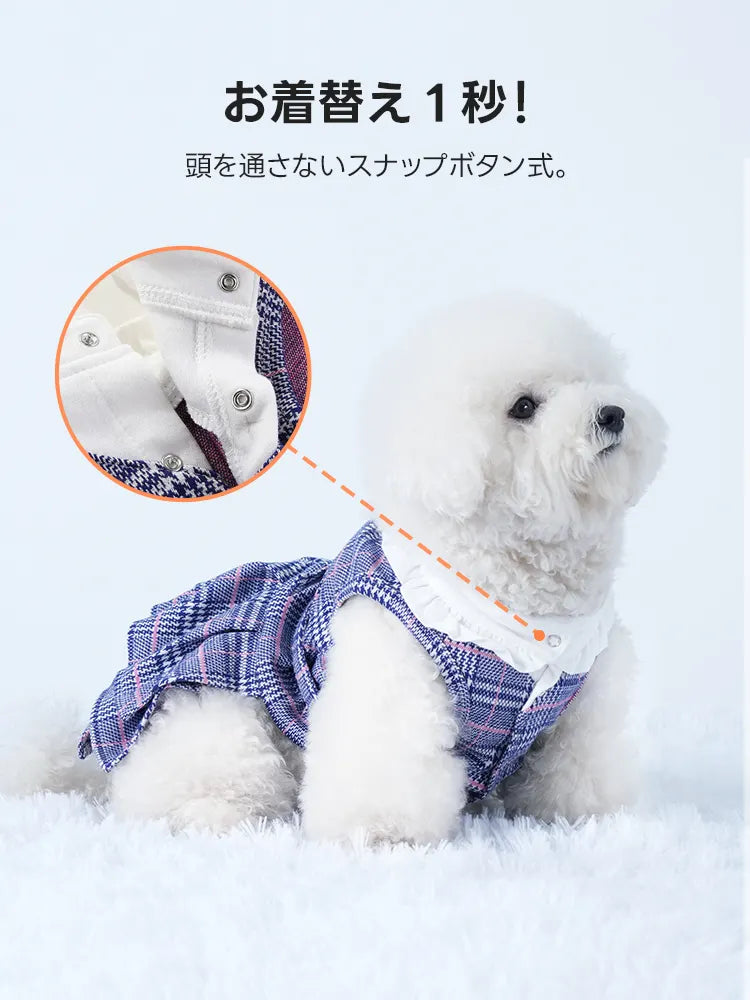 首元のスナップボタンを拡大した詳細画像。白いフリル襟の下に配置されたシルバーのボタンで、頭を通さずに着脱可能。青いチェック柄の生地とフリルの質感が確認でき、機能性とデザインのこだわりが伝わる細部紹介。