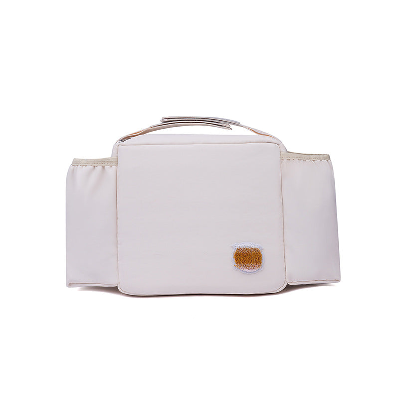 撥水ポリエステル素材を使用したアイボリーのマルチ収納バッグ。中央の可愛いワンポイント刺繍と、整理整頓しやすい左右対称のポケット配置が特徴。