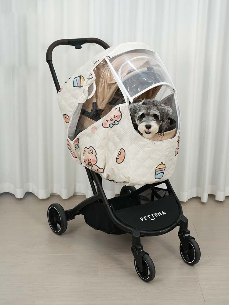 キャラクター柄のカバーから顔を出すシュナウザー。大型透明窓により装着したまま愛犬の様子を確認でき、窓を開けて直接ケアも可能なMILOU/ORION専用設計。