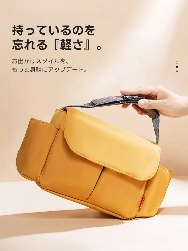 2WAY防水カート用バッグ。驚きの軽さを片手で持ち上げるシーンで表現。日常の散歩をスタイリッシュ且つ身軽に彩ります。マスタード色の洗練されたデザインが、都会的なお出かけシーンにマッチします。