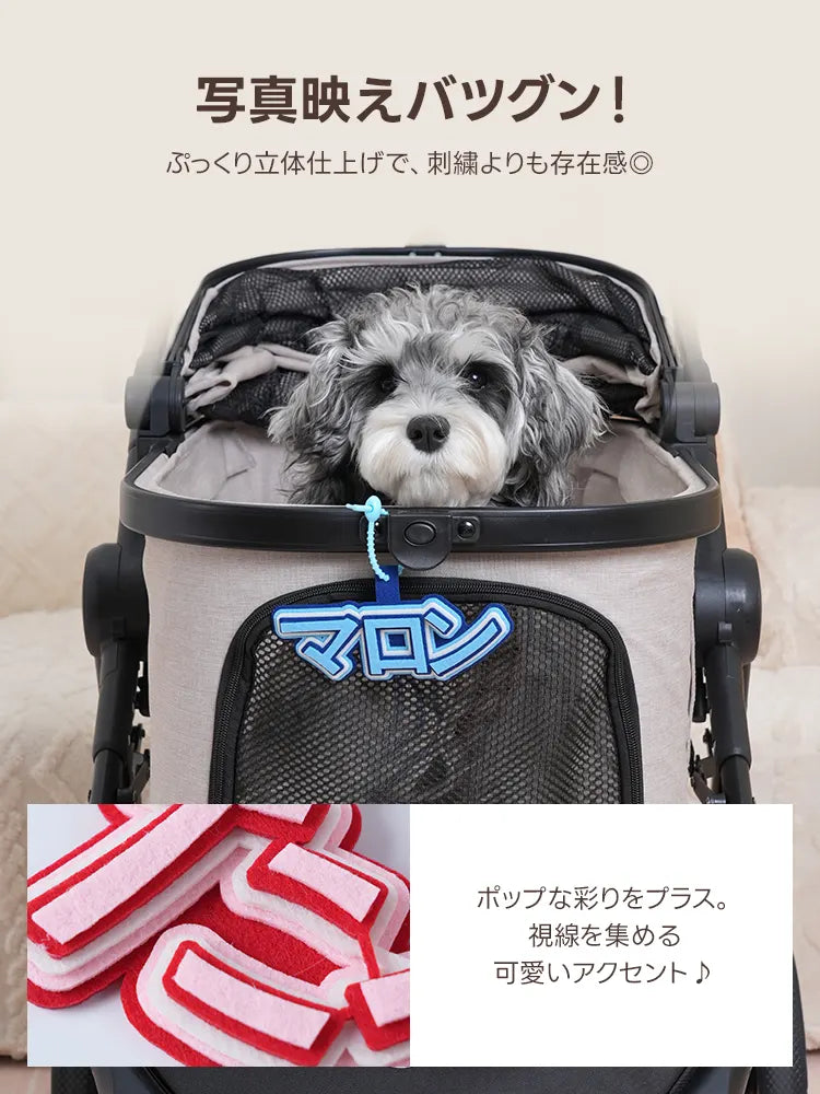 刺繍より存在感のある「ぷっくり立体仕上げ」の名入れチャーム。ペットカートに装着した際の視認性の良さと、フェルトを重ねた厚みのある質感をクローズアップで紹介しています。ポップな配色が視線を集める、お出かけの際の可愛いアクセントに最適です。