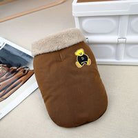 こっくりとしたコーヒー色の生地に、ベージュのボア襟とクマのワッペンが映える犬用ジャケット。背中にはリードを通すためのスリットがあり、実用的なディテールを紹介。