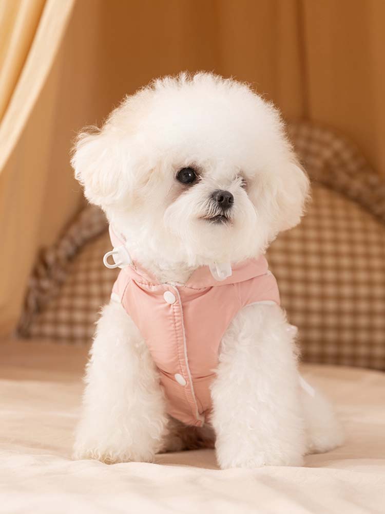 首元のフィット感を調整できるドローコード付きの犬用防寒服。前開きのスナップボタン仕様で、着せやすさを重視したピンク色のウェア。