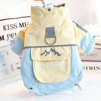 イエローと水色のバイカラー犬用ジャケット。背中の頑丈なDリングと、ロゴ入りの収納ポケットが特徴的な明るい配色の防寒着。