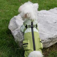 pettenaの一体型ハーネス付きレインロンパースグリーン。背中のバックルにリードを繋ぐだけで、雨の日の散歩へすぐに出発できる。