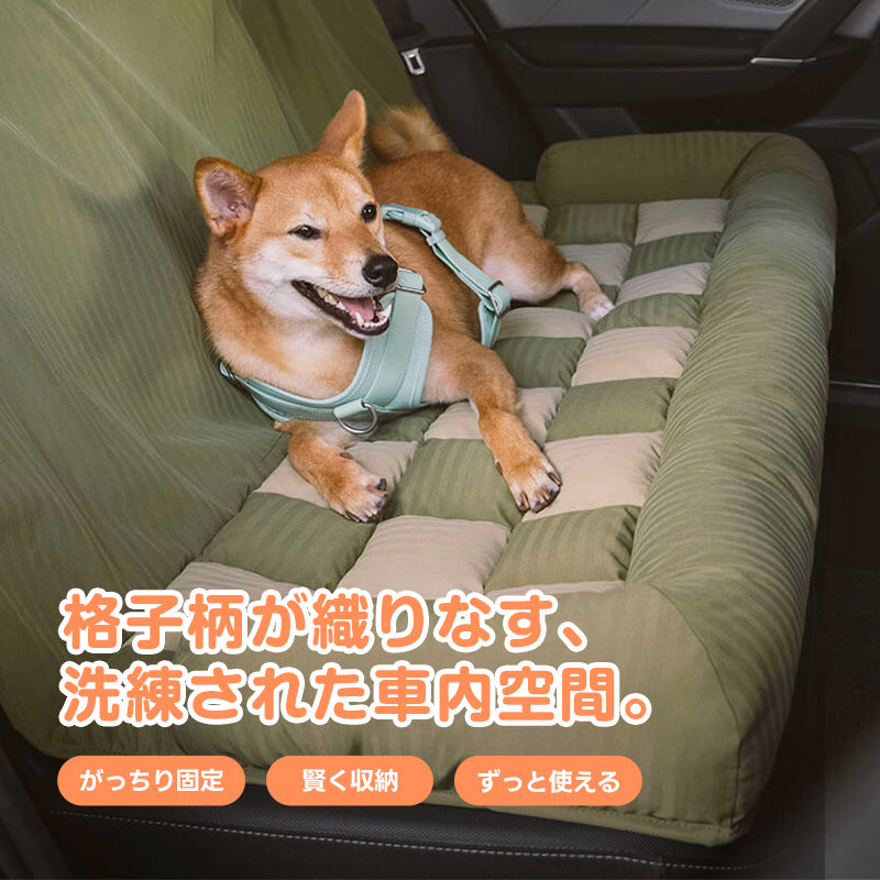 「後部座席用のPETTENAペット用カーシートに座る柴犬。緑の格子柄がおしゃれな車内を演出し、がっちり固定できるため、愛犬とのドライブがもっと安心に。」