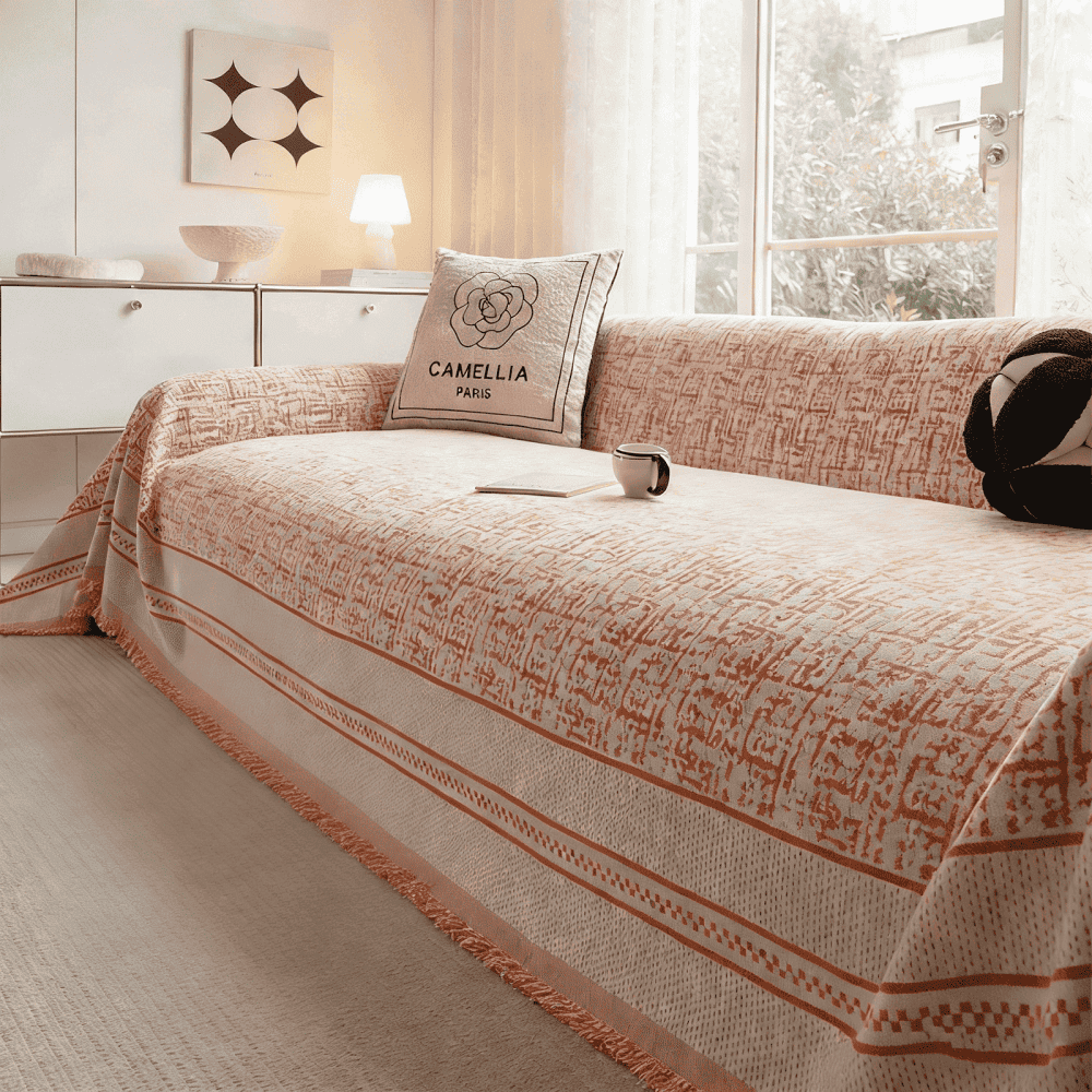 鮮やかなオレンジ色が部屋のアクセントになるPETTENAソファカバー。温かみのある幾何学模様とフリンジが、明るく元気なリビング空間を演出。