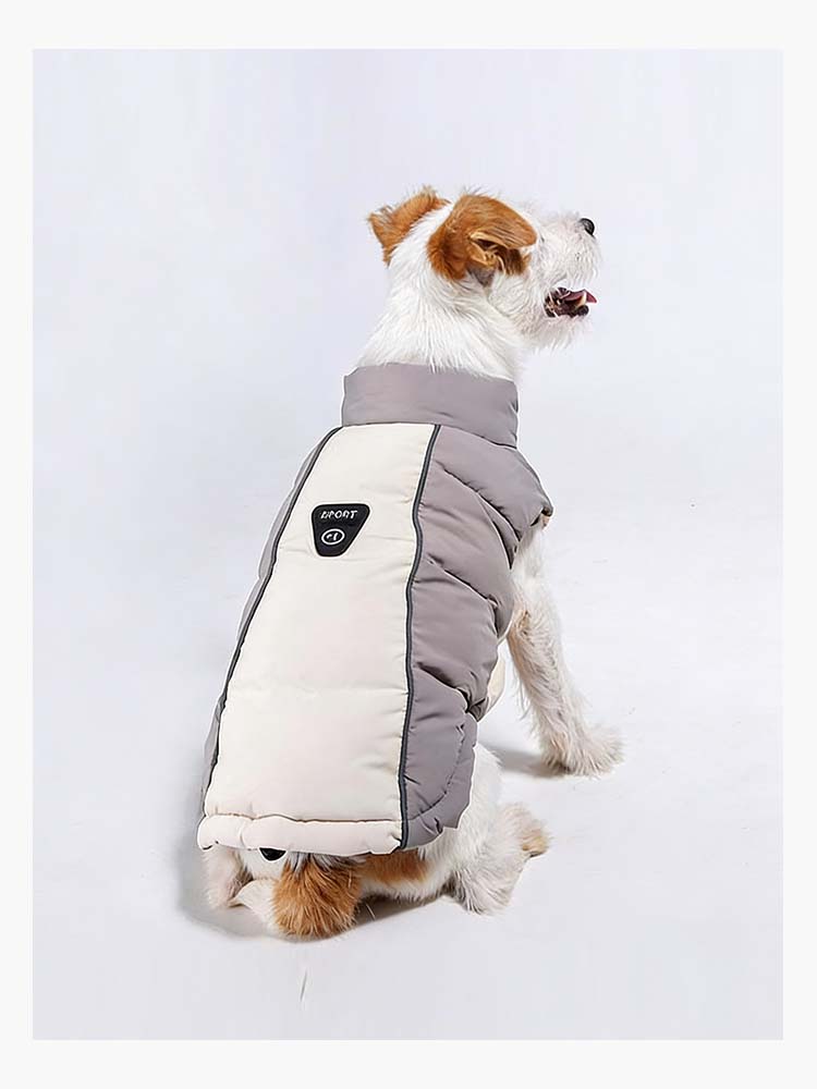 グレーとベージュのシックな配色の中綿ダウンジャケットを着用した愛犬の背面図。背中のロゴパーツと縦に走る反射材ラインが特徴的で、首元をしっかり覆う立ち襟設計が冷気の侵入を防ぎ、後ろ姿までスタイリッシュに演出。