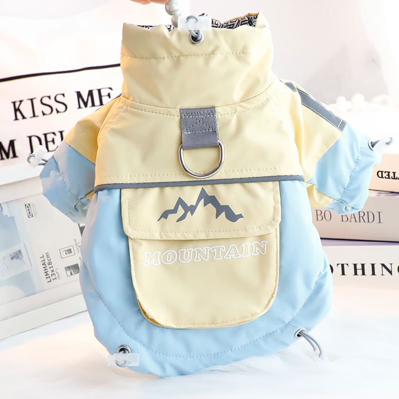 イエローと水色のバイカラー犬用ジャケット。背中の頑丈なDリングと、ロゴ入りの収納ポケットが特徴的な明るい配色の防寒着。