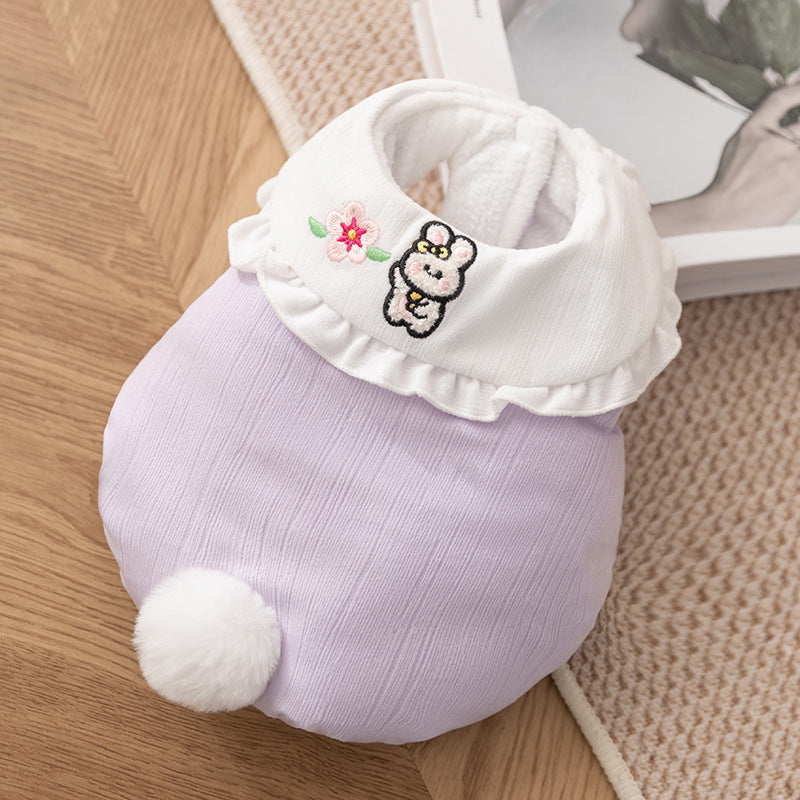 リル襟と刺繍がポイントのパープルの犬猫兼用ベスト。甘すぎない上品な色味で、白いしっぽの飾りが後ろ姿のアクセントになり、幅広い毛色のペットに似合うデザインです。