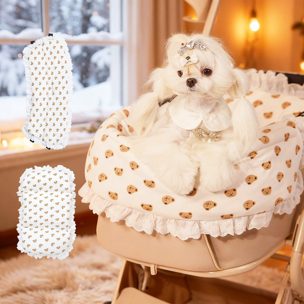 PETTENAベアプリントクッショ、雪の積もる窓辺で、白い小型犬がベアプリントのあごのせクッションに囲まれている。クッションは白地に茶色の小さなくまが散りばめられ、厚みがあり暖かそう。左側に製品の全体図も表示。